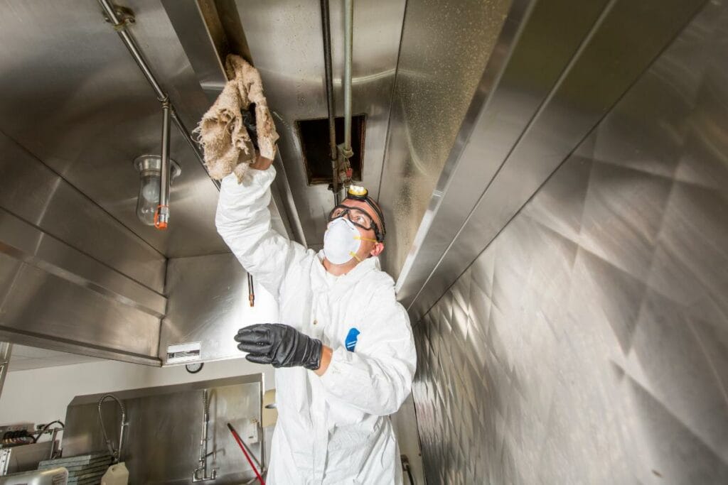 professionnel en tenue de protection en train de nettoyer interieur cuisine professionnelle oceanick nettoyage experts en nettoyage a quebec